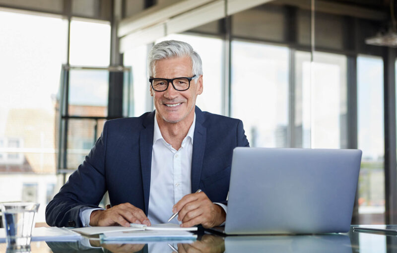 businessman-working-at-laptop-taking-notes-in-not-2022-12-16-22-27-36-utc.jpg